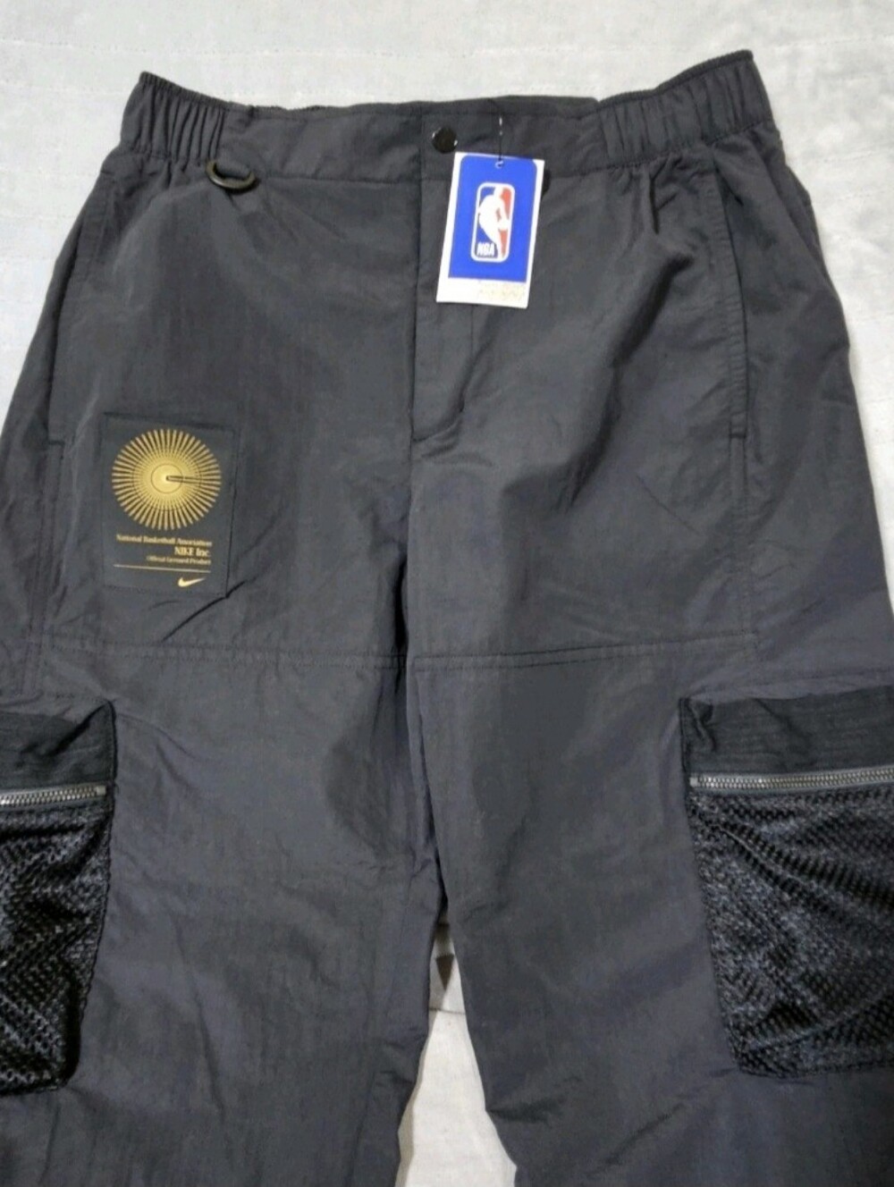 Nike Men’s Black Cargo Pants with Mesh Zip Pockets and NBA embroidered logo.
